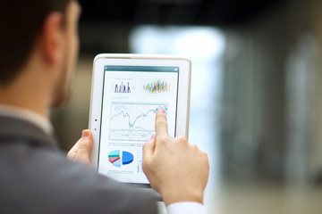 Fototapeta na wymiar Business person analyzing financial statistics displayed on the tablet screen