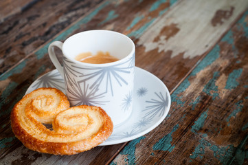 Freshly brewed cup of espresso coffee in a cup and saucer served with a traditional portugese biscuit.