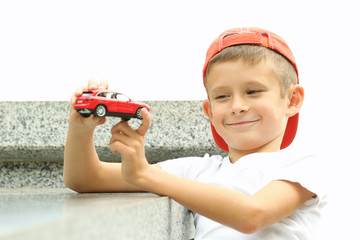 Obraz premium Little boy playing with toy car outside