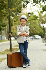 Fototapeta premium Little boy with suitcase in the park