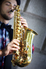 Obraz premium Saxophonist plays jazz outdoors, close up