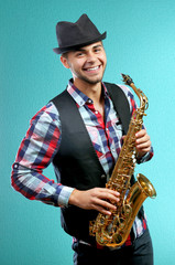 Fototapeta na wymiar Saxophone player on blue background