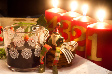 Festive spiced mulled wine with a small ornamental Father Christmas sitting on some gingerbread in...
