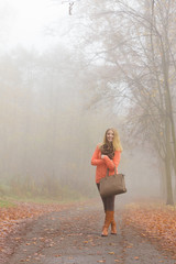 Happy fashion woman with handbag in autumn park