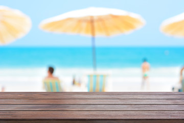 Old dark brown wood table top on blurred beach background