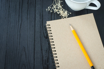 Note book and pencil and coffee time on wooden