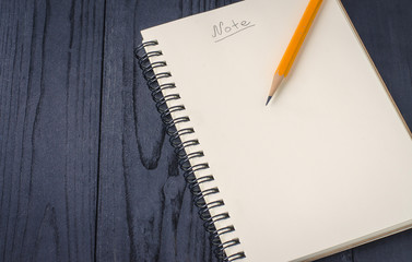 Note book and pencil on wooden