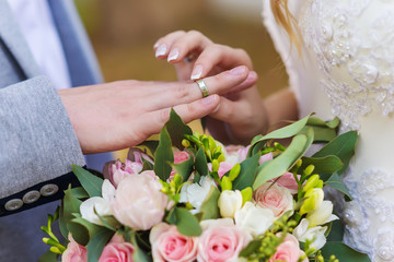Obraz na płótnie Canvas Bride puts on ring on the groom finger