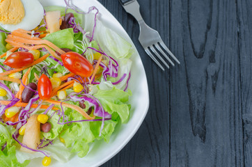  Fresh vegetable salad in dish on wooden selective focus