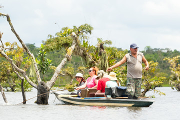 Adventurous tourists embarking on the unique experience of fishing for the legendary piranha fish in the depths of the Ecuadorian Amazonian primary jungle