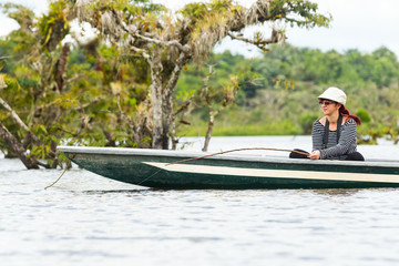 Woman engaged in the exhilarating activity of piranha fishing in the breathtaking landscapes of...