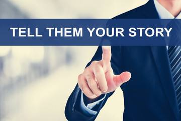 Businessman hand touching TELL THEM YOUR STORY message on virtual screen