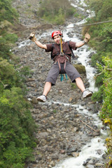 A group of people zip lining through the lush green rainforest, their bodies suspended by a thin line as they embark on an exciting adventure.