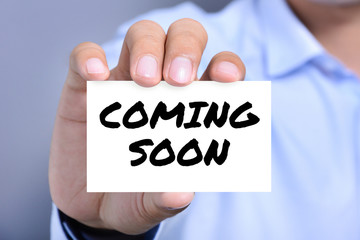 COMING SOON message on the card shown by a man