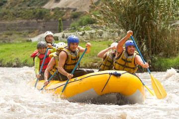 A young team enjoying the powerful and extreme whitewater rafting in Ecuador, navigating through the fun and thrilling rapids.