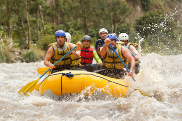 A thrilling adventure in Ecuador's whitewater river; a group of men on a white raft battling dangerous rapids, embracing the thrill and excitement.