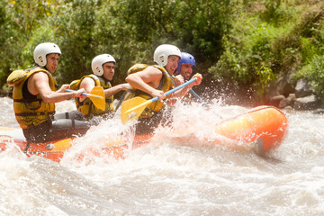 A team of rowers in Ecuador navigate a raft through the whitewater rapids of a river, competing in...