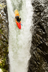 A thrilling image of a kayak navigating through white-water rapids near a majestic waterfall, showcasing the courage and extreme sport of water rafting.