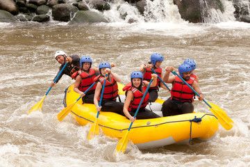 A group of women in a white raft navigate through the challenging whitewater rapids, laughing and having fun on their extreme sports adventure.