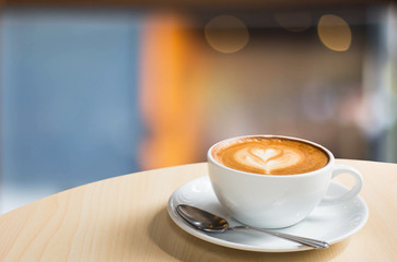 Hot art Latte Coffee in a cup on wooden table and Coffee shop bl