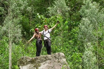 A couple of tourists zip lining through the lush Ecuadorian rainforest on an exhilarating adventure tour.