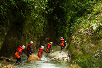 A group of adventurous people exploring the dangerous canyons of Ecuador's Llanganates, engaging in...