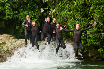 Experience the thrill of canyoning as a group of six people,three pairs,jump in unison into a stunning waterfall.