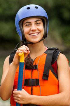Stunning portrait of a joyful young woman donning white water rafting gear,radiating happiness and adventure.