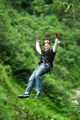 A group of people zip lining through the lush canopy of an Ecuadorian jungle, surrounded by...