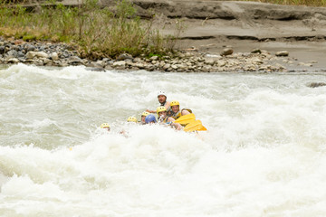 A diverse group of male and female tourists accompanied by a skilled guide embarking on a thrilling whitewater river rafting adventure in Ecuador