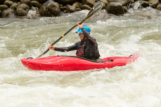 A thrilling image of a kayaker navigating through rough river rapids, displaying extreme skill and having fun in an action-packed water sport.