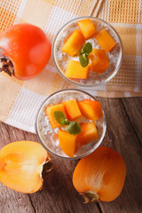 Yogurt with chia seeds and persimmon closeup. vertical top view
