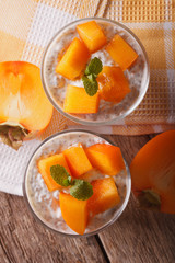 Chia seed pudding and persimmon close-up. vertical top view

