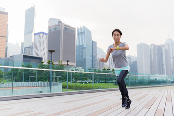 Fototapeta na wymiar Woman look at her wearable when running