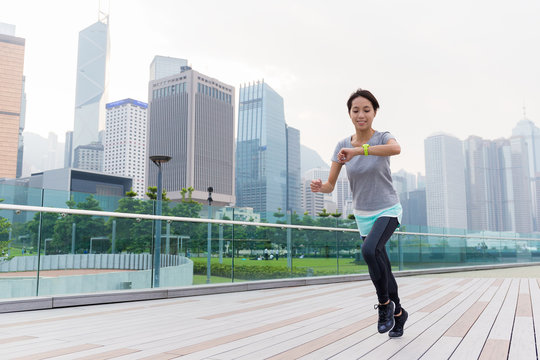 Woman look at her wearable when running - Powered by Adobe