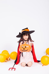 little girl in black hat  with halloween pumpkin