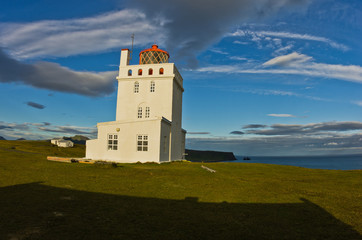 Fototapeta na wymiar Lighthouse at Dyrholaey rock at sunset with picturesque clouds
