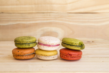 french colorful macarons on wooden floor