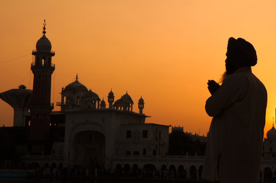 silhouette of pilgrim praying at the holy temple of amritsar, in