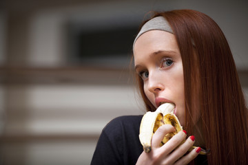 Woman is sitting in sport saloon and eating banana