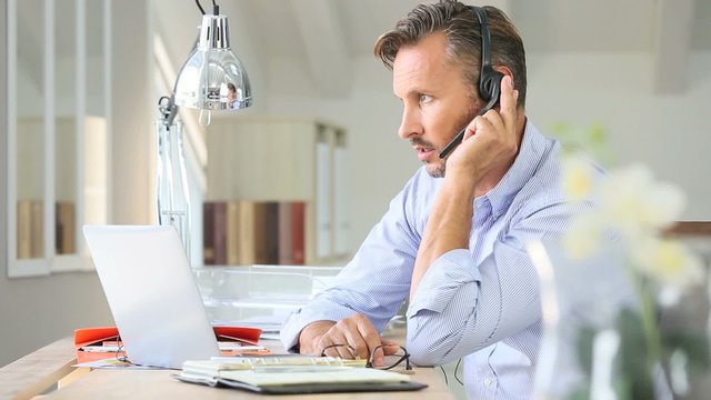Businessman teleworking, headset on