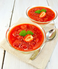 Dessert strawberry-vanilla in two glassful with spoon on board
