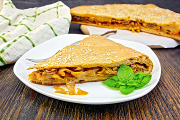 Pie with cabbage and sesame in plate on board with cloth