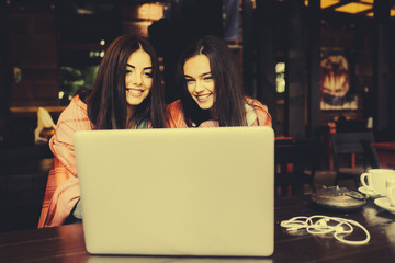 two girls watching something in laptop