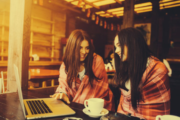 two girls watching something in laptop