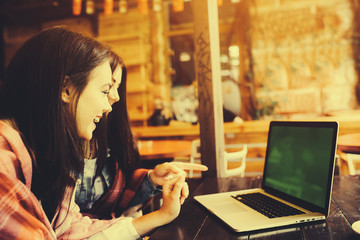 two girls watching something in laptop