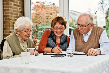 Elderly couple and daughter, making plans - obrazy, fototapety, plakaty