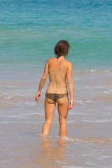 Young lady enters the sea. Indian ocean.