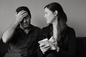 Worried husband and wife  listing expenses