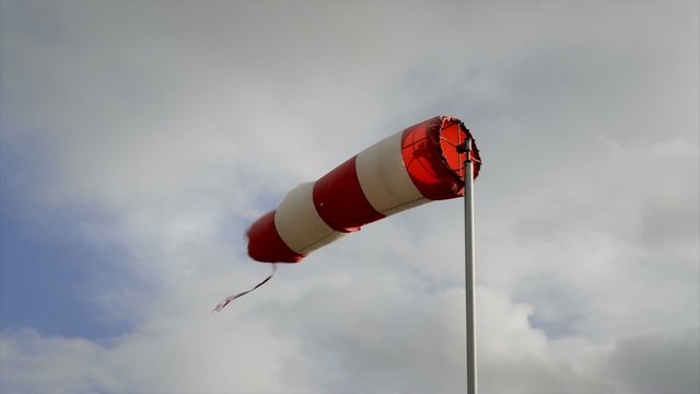 Red and white wind sign turning in the wind on a summer's day.